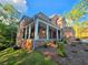 Side view of a brick home featuring a covered porch with classic columns and detailed stone accents at 7580 Sunridge Ln, Douglasville, GA 30135
