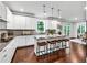 Bright kitchen boasts an island with seating, granite countertops, white cabinets, and stainless appliances at 7580 Sunridge Ln, Douglasville, GA 30135