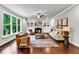 Bright living room featuring hardwood floors, a fireplace, and a large window overlooking the backyard at 7580 Sunridge Ln, Douglasville, GA 30135