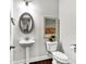 Tastefully decorated powder room features a pedestal sink, oval mirror, and elegant artwork at 7580 Sunridge Ln, Douglasville, GA 30135