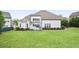 Back of the house with expansive green lawn, covered patio, and meticulously landscaped garden beds at 5950 Thoroughbred Way, Suwanee, GA 30024