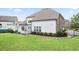 Green backyard with trimmed lawn, detailed garden beds, and a white patio for outdoor enjoyment at 5950 Thoroughbred Way, Suwanee, GA 30024