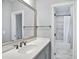Bathroom featuring a quartz countertop vanity, large mirror, and tub with shower at 5950 Thoroughbred Way, Suwanee, GA 30024