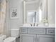 Bathroom with a large mirror over vanity, framed butterfly art, and shower with decorative curtains at 5950 Thoroughbred Way, Suwanee, GA 30024