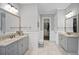 The dual vanity bathroom offers granite counters, grey cabinetry, and a view to a walk-in closet at 5950 Thoroughbred Way, Suwanee, GA 30024