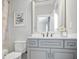 Stylish bathroom featuring grey cabinetry, artwork, and a large mirror at 5950 Thoroughbred Way, Suwanee, GA 30024