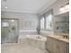 Bathroom features a walk-in shower, soaking tub, gray cabinets, and tile floors at 5950 Thoroughbred Way, Suwanee, GA 30024
