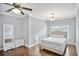 Bedroom with hardwood floors, large window, ceiling fan, and a white bed and furniture set at 5950 Thoroughbred Way, Suwanee, GA 30024