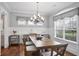 Well-lit dining room with modern chandelier, hardwood floors, and elegant window treatments at 5950 Thoroughbred Way, Suwanee, GA 30024