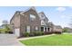 Two-story brick home with dark shutters, a driveway leading to a garage, and well-maintained landscaping at 5950 Thoroughbred Way, Suwanee, GA 30024