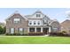 Attractive brick and stone home with a lush green lawn and manicured landscaping at 5950 Thoroughbred Way, Suwanee, GA 30024