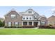 Beautiful two-story home featuring manicured front yard, brick and stone facade, dormers, and covered entry at 5950 Thoroughbred Way, Suwanee, GA 30024