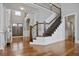 Grand foyer with hardwood floors, staircase with iron railing, and double front doors at 5950 Thoroughbred Way, Suwanee, GA 30024
