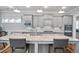 Open kitchen with granite counters, stainless appliances, pendant lighting, and large island with seating at 5950 Thoroughbred Way, Suwanee, GA 30024