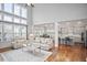Open-concept living room and kitchen with tall windows and hardwood floors at 5950 Thoroughbred Way, Suwanee, GA 30024