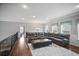 Open living room featuring a sectional sofa, area rug, hardwood floors and natural light at 5950 Thoroughbred Way, Suwanee, GA 30024