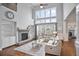 Bright living room boasts two-story windows, a stone fireplace, hardwood floors, and stylish white furniture at 5950 Thoroughbred Way, Suwanee, GA 30024