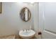 Modern half bath with a pedestal sink, decorative mirror, and elegant fixtures at 900 River Vista Dr, Atlanta, GA 30339