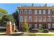 Attractive three-story brick townhome featuring manicured landscaping and a rooftop terrace at 900 River Vista Dr, Atlanta, GA 30339