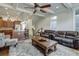 Bright living room with coffered ceilings, ceiling fan, leather couches, and open access to a modern kitchen at 900 River Vista Dr, Atlanta, GA 30339