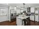 Stylish white kitchen featuring stainless steel appliances, a granite island with seating, and hardwood floors at 1865 Lochlomand Se Ln, Smyrna, GA 30080