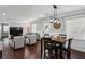 Open-concept living area with hardwood floors, a comfortable sofa, dining table and a large TV at 1865 Lochlomand Se Ln, Smyrna, GA 30080