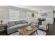 Cozy living room featuring a gray sofa, hardwood floors, and access to the dining room and other rooms at 1865 Lochlomand Se Ln, Smyrna, GA 30080