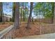 An exterior view of the backyard featuring mature trees and a wooden fence at 2199 Summertown Dr, Norcross, GA 30071