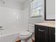 Well-lit bathroom features a shower-tub combination and a dark wood vanity with granite countertops at 2199 Summertown Dr, Norcross, GA 30071