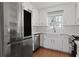 Modern kitchen boasts stainless steel appliances and a farmhouse sink with white cabinets and light countertops at 2199 Summertown Dr, Norcross, GA 30071