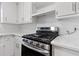 A stainless steel gas range is the focal point of this kitchen with white cabinets and light countertops at 2199 Summertown Dr, Norcross, GA 30071