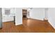Open-concept living space with wood floors, white walls, fireplace, and adjacent kitchen at 2199 Summertown Dr, Norcross, GA 30071