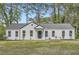 Newly renovated single story house with white siding, black trim, and a landscaped front yard with mature trees at , Atlanta, GA 30311