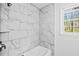 Elegant marble tile in the bathroom shower provides a luxurious and modern feel, complemented by a window view at 240 Thornton Dr, Fayetteville, GA 30214