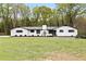 Charming white home with black shutters and a well-maintained lawn provides wonderful curb appeal at 240 Thornton Dr, Fayetteville, GA 30214