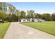 Wide shot of beautiful single-story white home with long driveway and a well-manicured lawn at 240 Thornton Dr, Fayetteville, GA 30214