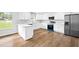 Bright kitchen featuring white cabinets, stainless steel appliances, and wood-look flooring at 240 Thornton Dr, Fayetteville, GA 30214
