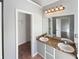 Bathroom showcasing a dual sink vanity with decorative lighting, a mirror, and closet space at 46 Norman Rd, Covington, GA 30014