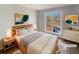 Staged bedroom with a large window, neutral walls, hardwood floors, and modern decor at 46 Norman Rd, Covington, GA 30014