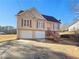 Two-story house features beige siding, dark roof, a two-car garage, and a well-kept yard at 46 Norman Rd, Covington, GA 30014