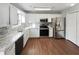 Well-lit kitchen with stainless steel appliances, granite counters, and a wood floor at 46 Norman Rd, Covington, GA 30014
