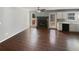 Bright living room with dark hardwood floors, a fireplace, and windows with a view to the backyard at 46 Norman Rd, Covington, GA 30014