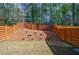 Landscaped backyard featuring modern privacy fence, grass lawn, and plantings at 5010 Towneship Creek Rd, Roswell, GA 30075