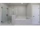 Bright bathroom featuring a glass shower and separate marble trimmed soaking tub at 5010 Towneship Creek Rd, Roswell, GA 30075