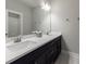 Bathroom featuring double sinks, vanity, large mirror, and modern lighting at 5010 Towneship Creek Rd, Roswell, GA 30075