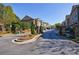 Upscale townhome community entrance featuring stone pillars, wrought iron gates, and beautifully landscaped grounds at 5010 Towneship Creek Rd, Roswell, GA 30075