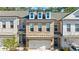 Charming brick townhome featuring a two-car garage and a covered front porch entry at 5010 Towneship Creek Rd, Roswell, GA 30075