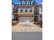 Beautiful brick townhome with two-car garage, dormer windows, and professionally landscaped front yard at 5010 Towneship Creek Rd, Roswell, GA 30075