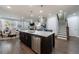 Spacious kitchen with stainless steel appliances, large island with barstools, and open view to dining and living areas at 5010 Towneship Creek Rd, Roswell, GA 30075