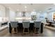 Stylish kitchen island with pendant lighting, modern appliances, white cabinetry, and adjacent dining area at 5010 Towneship Creek Rd, Roswell, GA 30075